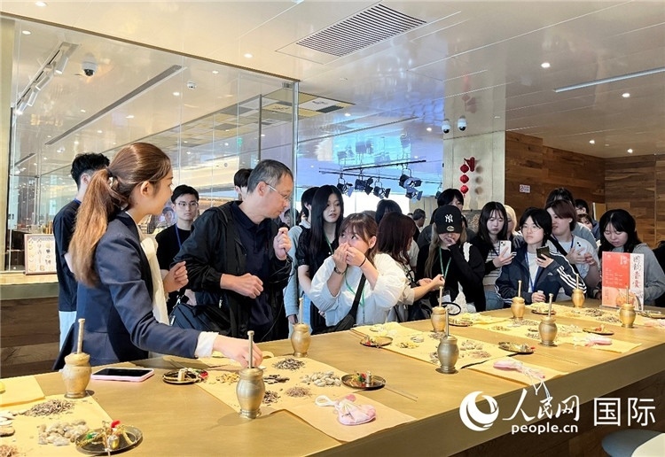 1. 日中友好協(xié)會(huì)青年代表團(tuán)一行學(xué)習(xí)中醫(yī)香囊制作工序。（人民網(wǎng)記者陳思 攝）
