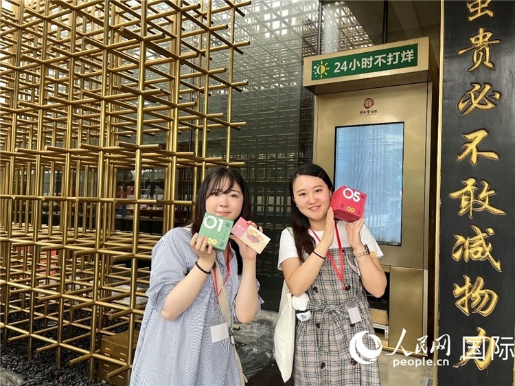 5. 代表團(tuán)團(tuán)員展示通過(guò)無(wú)人售藥機(jī)購(gòu)買的盲盒。（人民網(wǎng)記者陳思 攝）