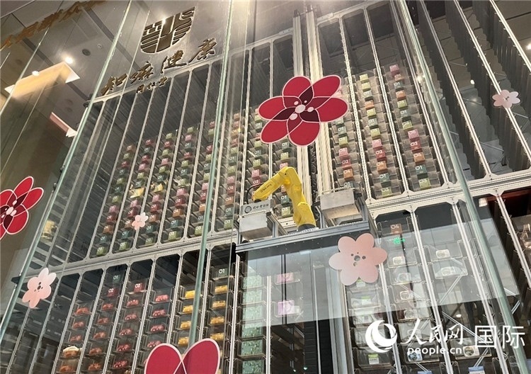 6. 機(jī)械臂正在取貨。（人民網(wǎng)記者陳思 攝）