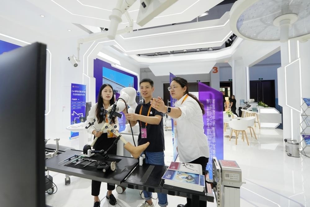 9月11日，一位媒體記者（中）在2024年服貿(mào)會(huì)國(guó)家會(huì)議中心會(huì)場(chǎng)體驗(yàn)北京納通科技集團(tuán)有限公司的膝關(guān)節(jié)置換手術(shù)機(jī)器人。新華社記者鞠煥宗 攝