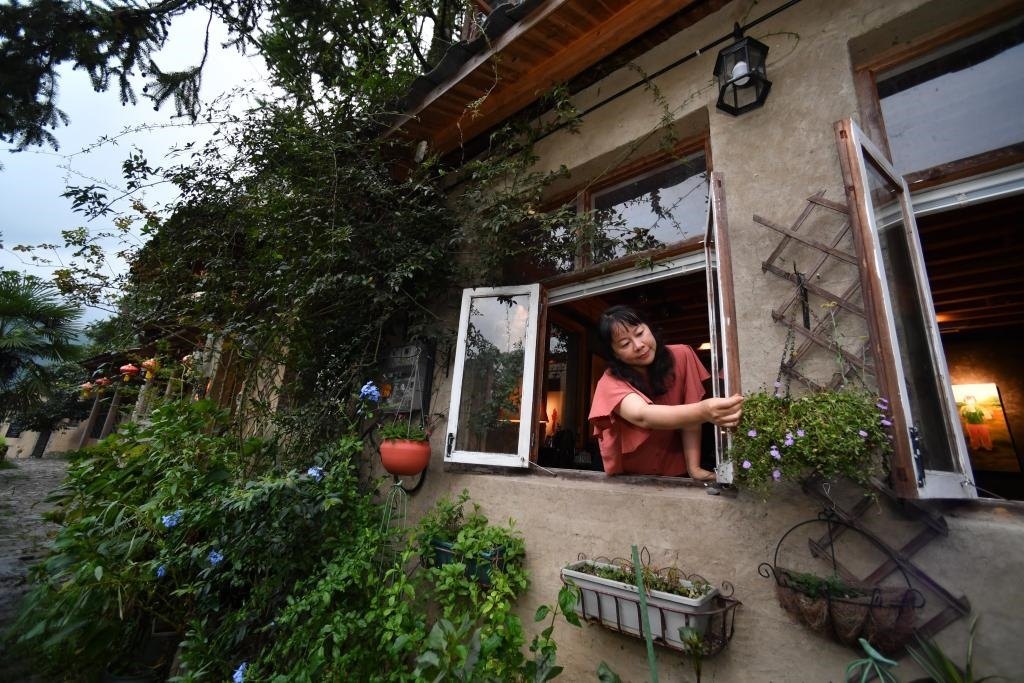 8月29日，在福建省屏南縣熙嶺鄉(xiāng)，龍?zhí)洞濉靶麓迕瘛泵泛暝诖蚶碜约航?jīng)營的民宿外墻裝飾花盆。新華社記者姜克紅 攝