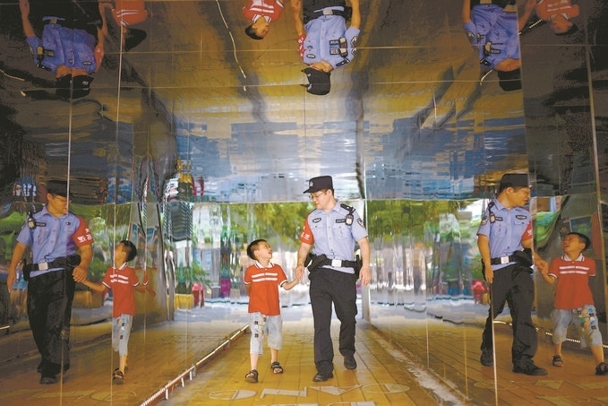 ?7月16日，重慶市公安局江北區(qū)分局一名民警在巡邏途中遇到一個獨自玩耍的小男孩，民警將其送回家。王洪平攝