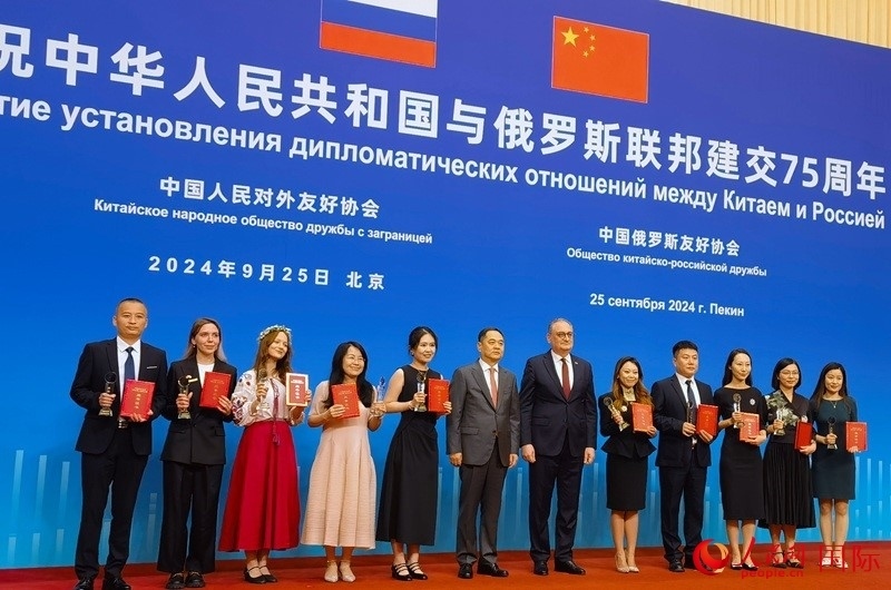 楊萬明會長和莫爾古洛夫大使為10位中俄青年友好微視頻創(chuàng)意大賽獲獎代表頒獎。人民網(wǎng)記者 李明琪攝