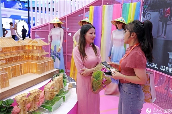 參觀者在東博會(huì)越南展區(qū)同工作人員咨詢交談。人民網(wǎng)記者 趙益普攝