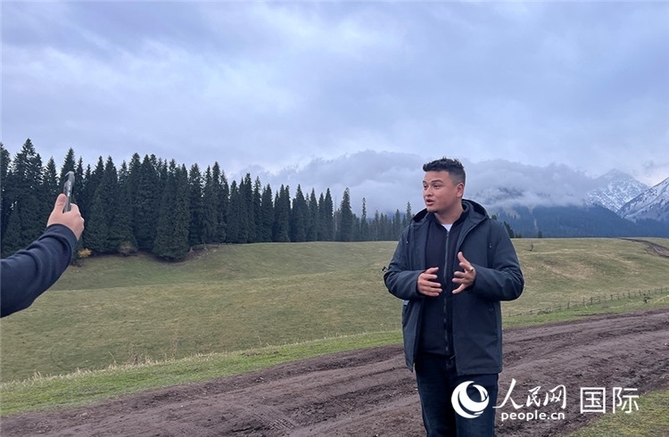 在庫爾德寧，吾買爾江被雪山美景震撼，即興錄制了短視頻作品。人民網(wǎng)記者曾書柔攝