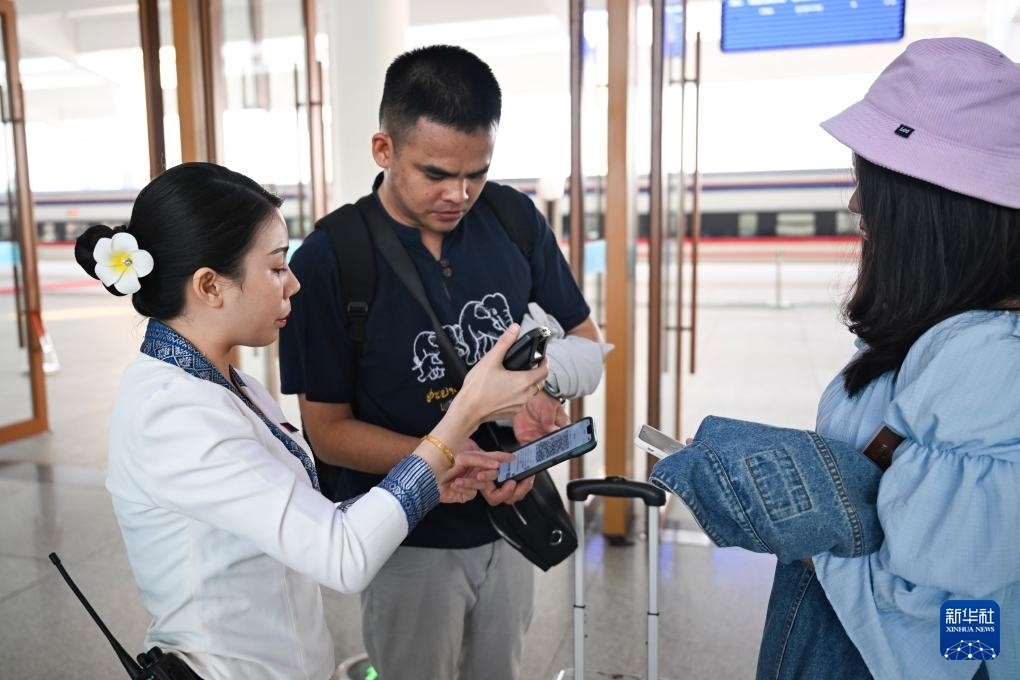 10月12日，在老撾萬象中老鐵路萬象站，工作人員檢驗乘客車票。新華社記者 程一恒 攝