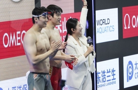  10月18日，汪順（左）和潘展樂在男子100米混合泳決賽后。新華社記者 方喆 攝