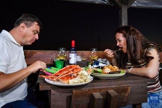 9月2日，食客們?cè)诙砹_斯符拉迪沃斯托克的一家餐館品嘗帝王蟹。新華社記者 曹陽(yáng) 攝