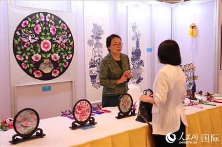 青海非遺文化傳承人向嘉賓介紹展品。人民網(wǎng)實習生姚欣可攝