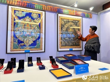 熱貢藝術(shù)國家級代表性傳承人夏吾角向嘉賓介紹作品。人民網(wǎng)記者 簡承淵攝