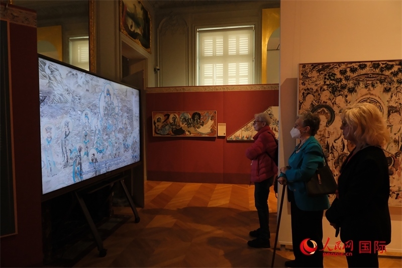 觀眾在展臺(tái)觀看錄像講解。人民網(wǎng)記者 尚凱元攝