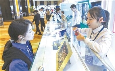 在北京麗澤商務(wù)區(qū)，工作人員（右一）介紹數(shù)字人民幣SIM卡硬錢包。新京報(bào)記者 陶冉攝