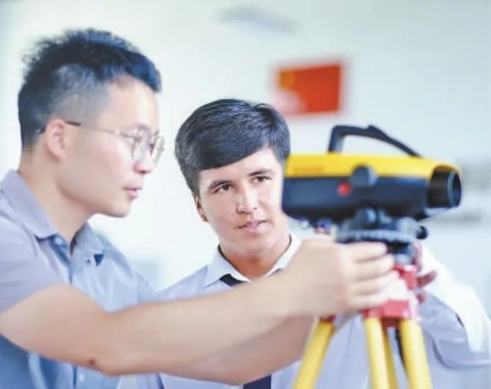 在塔吉克斯坦首都杜尚別的魯班工坊，來自天津城市建設(shè)管理職業(yè)技術(shù)學(xué)院的老師（左）為當?shù)貙W(xué)生提供指導(dǎo)。新華社記者 鄭開君 攝