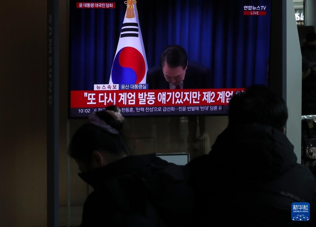 12月7日，在韓國(guó)首爾火車站，民眾觀看總統(tǒng)尹錫悅發(fā)表講話的電視畫面。新華社記者 姚琪琳 攝