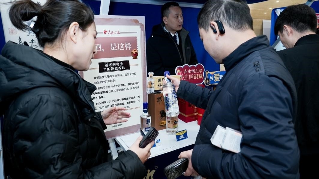 白酒展位負責人在為嘉賓介紹。張新攝