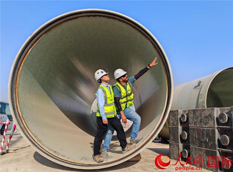 工作人員在察看輸水管情況。人民網(wǎng)記者 管克江攝