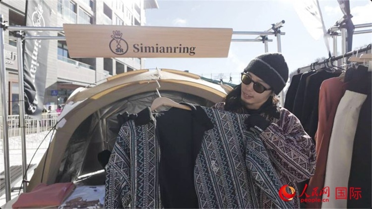 藤田周正在展示自己設(shè)計的滑雪服。人民網(wǎng)記者 袁蒙攝