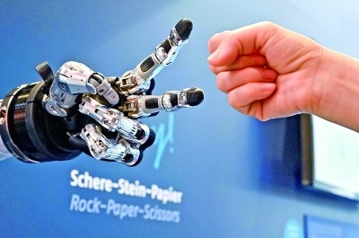 在德國漢諾威工博會(huì)上，參觀者與一款智能機(jī)器人進(jìn)行“石頭剪子布”游戲。新華社發(fā)