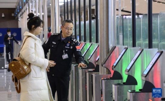 1月2日，大興機場邊檢站警察指導(dǎo)旅客使用自助出境設(shè)備。新華社記者 李欣 攝