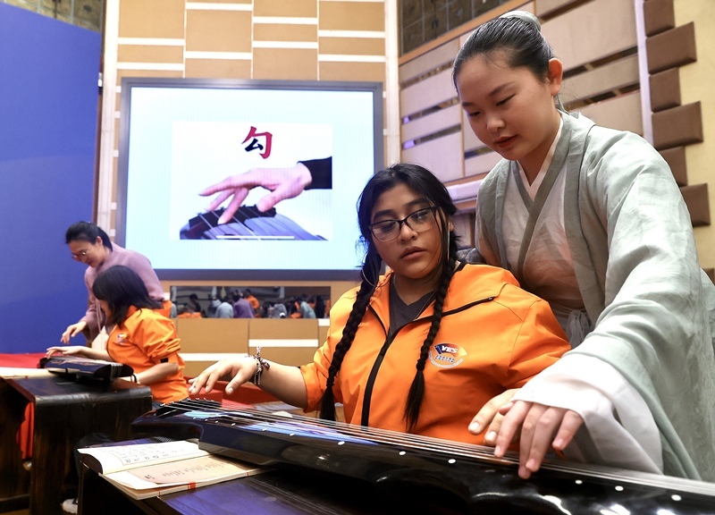 2024年3月20日，美國(guó)華盛頓州中學(xué)生代表團(tuán)北京大學(xué)交流活動(dòng)在北京大學(xué)英杰交流中心舉行。圖為來(lái)自華盛頓州的中學(xué)生體驗(yàn)古琴。