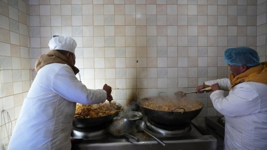 1月14日，服務(wù)隊的兩名廚師正在為村民們做午飯。新華社記者 邱星翔 攝