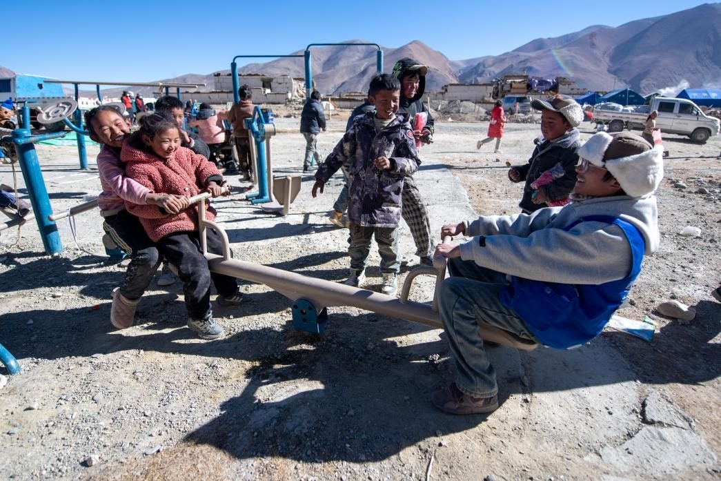 1月11日，在定日縣措果鄉(xiāng)塘仁村安置點(diǎn)，西藏星光社會(huì)工作服務(wù)中心志愿者和孩子們一起玩耍，進(jìn)行災(zāi)后心理疏導(dǎo)。人民網(wǎng)記者 翁奇羽攝
