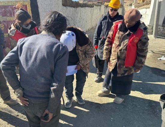 1月13日，次旺（右一）陪同工作組走訪村莊，評估房屋受損程度。新華社發(fā)