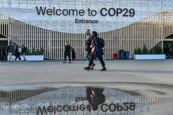 2024年11月15日，在阿塞拜疆首都巴庫(kù)，人們經(jīng)過(guò)聯(lián)合國(guó)氣候變化巴庫(kù)大會(huì)的會(huì)場(chǎng)。新華社記者 曹陽(yáng) 攝