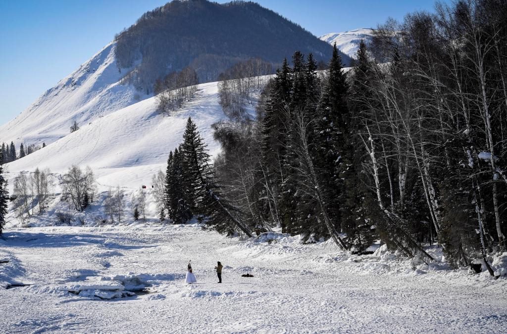 2024年2月5日，兩名游客在新疆阿勒泰地區(qū)布爾津縣禾木村拍照。新華社記者 馬鍇 攝