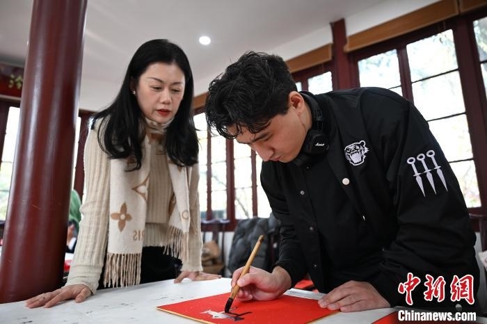 1月20日，外籍留學(xué)生在西泠印社社員李硯指導(dǎo)下寫福。當(dāng)日，來(lái)自巴西、馬來(lái)西亞、加納、哈薩克斯坦的外籍留學(xué)生在浙江杭州西泠印社體驗(yàn)福貼、春聯(lián)和篆刻，感受古老的中國(guó)傳統(tǒng)文化。中新社記者 王剛 攝