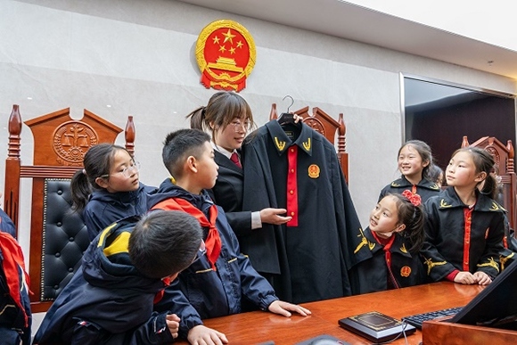 圖②：干警向同學(xué)們介紹法袍。