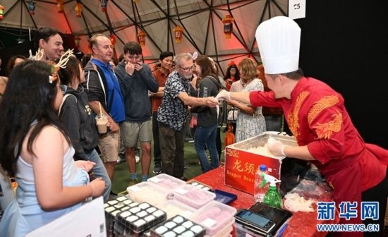 圖為游客在燈節(jié)現(xiàn)場購買小吃。（圖片由奧克蘭中國文化中心提供）
