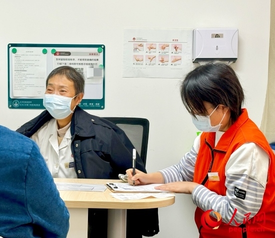 秦苑（中）接診患者。人民網(wǎng)記者 金慧慧攝