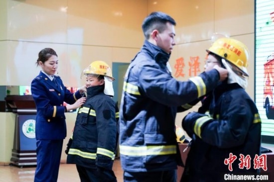 圖為學(xué)生們現(xiàn)場(chǎng)穿戴消防頭盔和戰(zhàn)斗服。中新社記者 趙宇航 攝