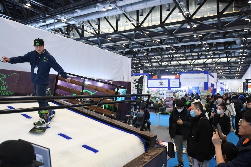 2023年2月11日，參觀者在展會上了解一款模擬滑雪設(shè)備。當(dāng)日，2023亞洲運動用品與時尚展在國家會議中心拉開帷幕。新華社記者 張晨霖 攝