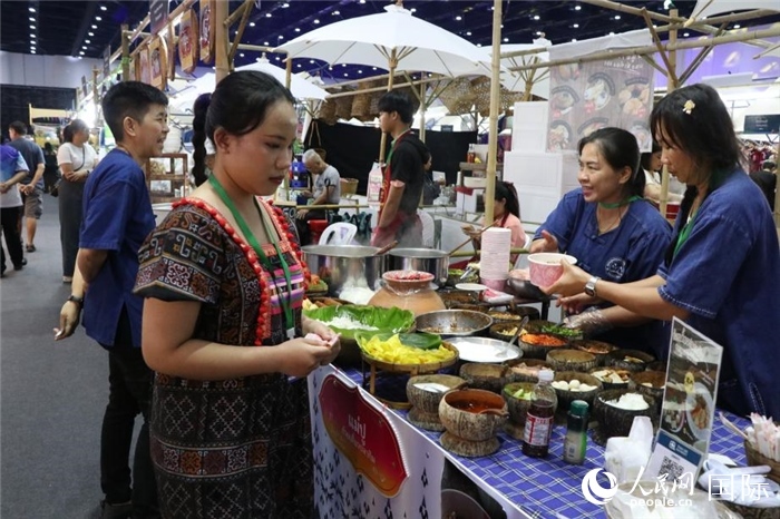 游客在攤位前購買特色美食。朱瀟逸攝