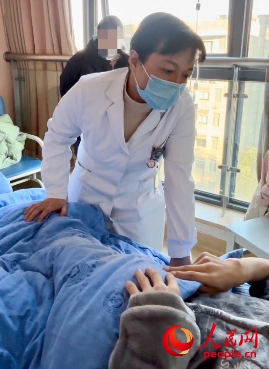 鄧茜查房時(shí)詢問患者情況。人民網(wǎng)記者 金慧慧攝