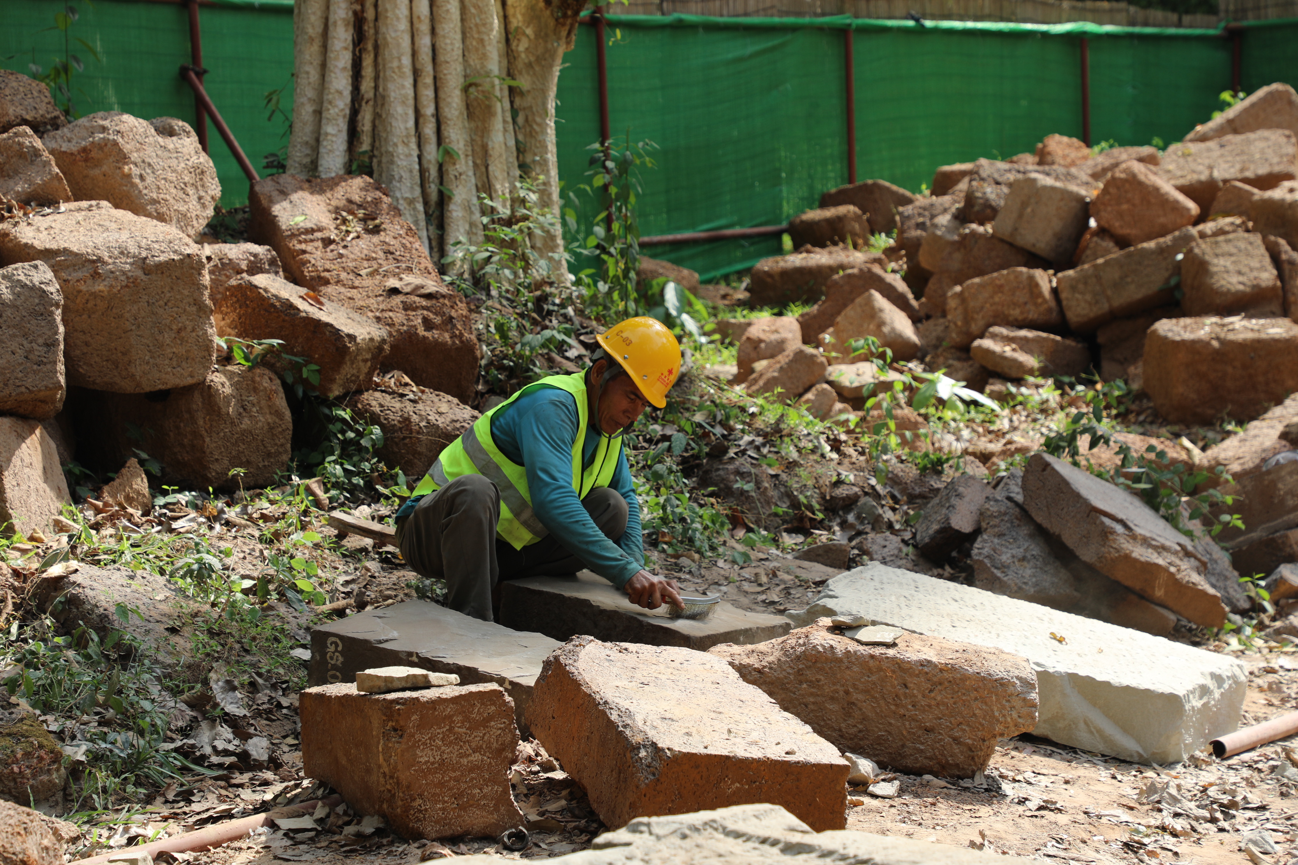 一名柬埔寨工人正在王宮遺址修復(fù)現(xiàn)場(chǎng)工作。（人民日?qǐng)?bào)記者曹師韻 攝）