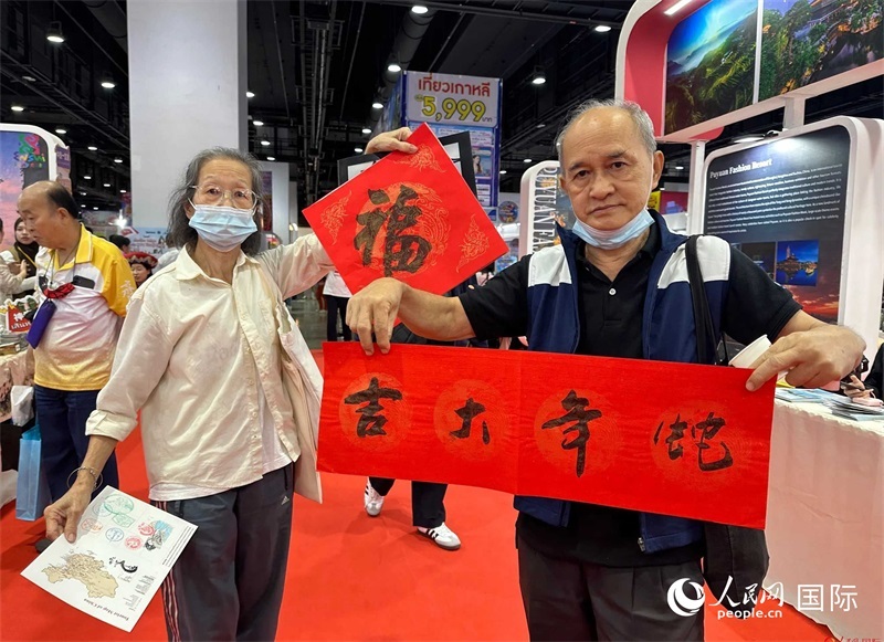 2025蛇年春節(jié)，泰國(guó)市民展示他們領(lǐng)到的華人手寫春聯(lián)。人民網(wǎng)記者 簡(jiǎn)承淵攝