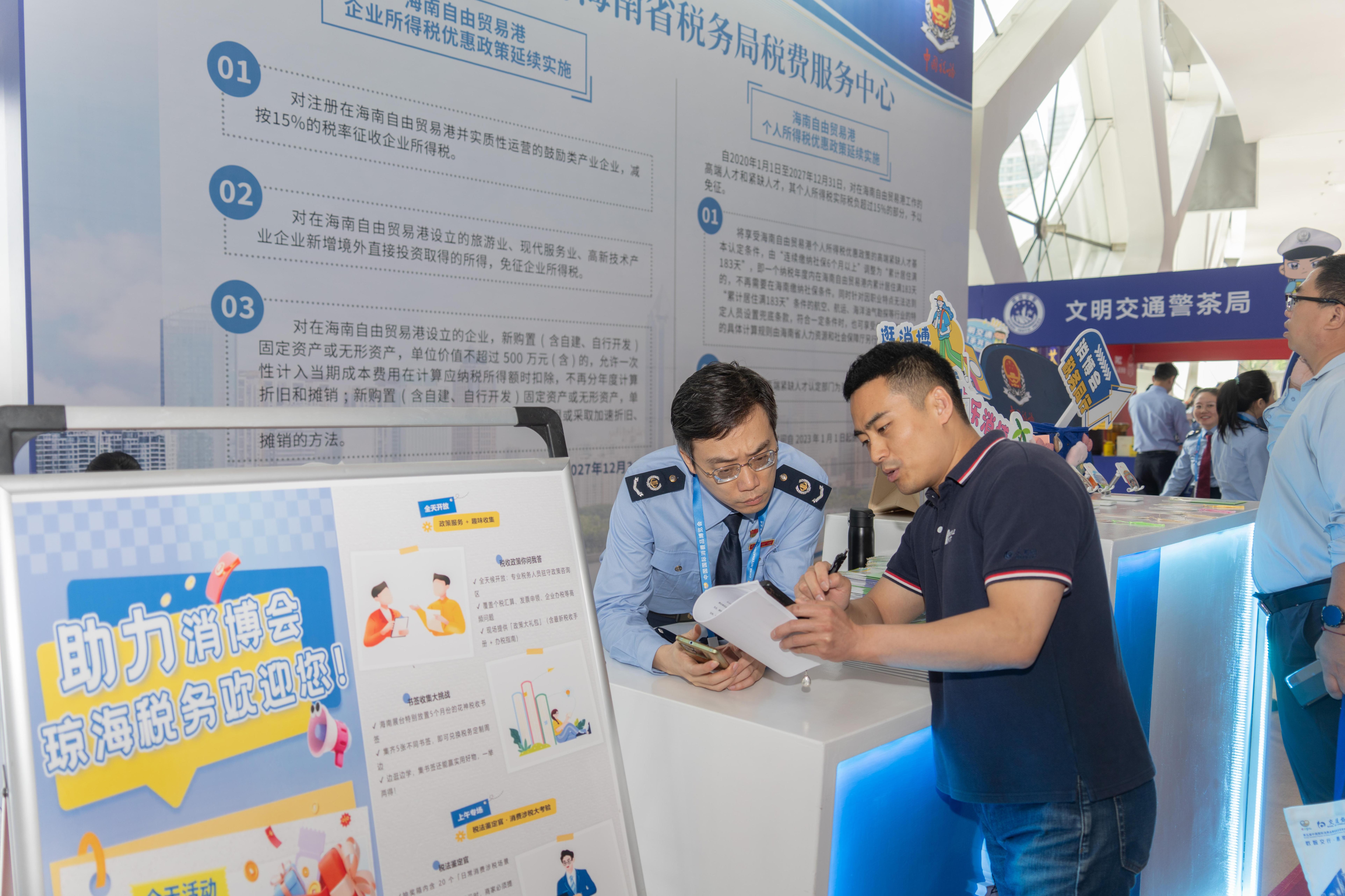 稅務服務臺工作人員向記者介紹服務參展外商的具體舉措。人民網(wǎng)記者 許崢攝