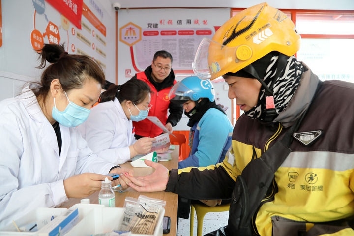 2025年3月5日，志愿者在山東省棗莊市市中區(qū)一工會驛站為外賣員免費(fèi)測量血糖。新華社發(fā)（王海楠攝）