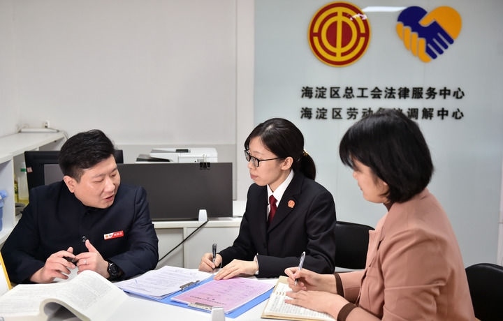 2025年3月6日，在北京市海淀區(qū)總工會勞動爭議調(diào)解中心，海淀區(qū)人民法院法官王琰（中）與該中心工作人員就糾紛化解情況進(jìn)行溝通。新華社記者 趙婷婷 攝