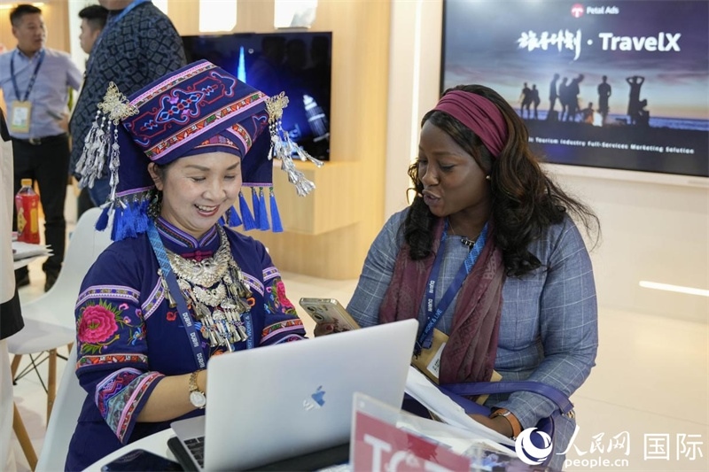 來(lái)自廣西的旅游業(yè)者同客戶交流。人民網(wǎng)塔里克·易卜拉欣攝