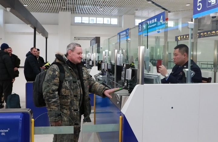 2024年12月10日，在黑河公路口岸旅檢大廳，黑河出入境邊防檢查站民警為首班次客車入境旅客辦理邊檢通關(guān)手續(xù)。當(dāng)日，中國(guó)黑河公路口岸—俄羅斯卡尼庫(kù)爾干公路口岸旅客運(yùn)輸正式開通。新華社發(fā)（劉松攝）