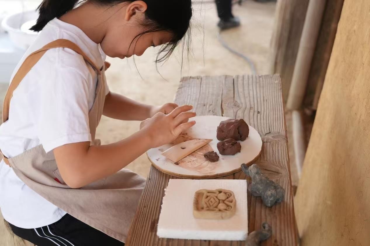 游客制作良渚特色陶藝品。良渚博物院供圖