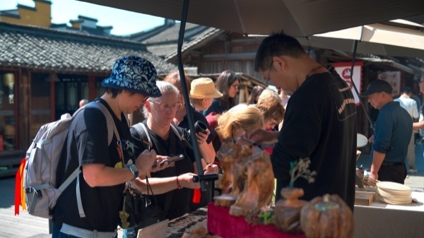 “五一”期間，游客正在烏鎮(zhèn)“水鄉(xiāng)碼頭”挑選購(gòu)買文創(chuàng)產(chǎn)品。受訪者供圖