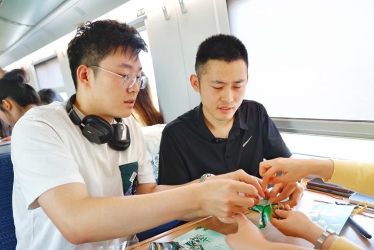G232次旅客親手制作端午荷包和五彩繩。王磊攝