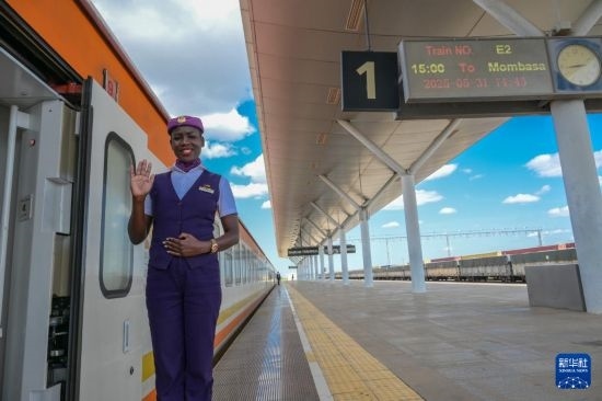 5月31日，在蒙內(nèi)鐵路內(nèi)羅畢站，一名乘務員在即將開往蒙巴薩的E2次列車旁等候乘客。新華社記者 楊光 攝