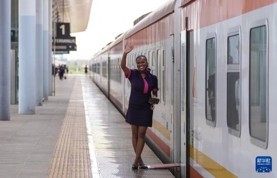 5月31日，在蒙內(nèi)鐵路內(nèi)羅畢站，一名乘務員在即將開往蒙巴薩的E2次列車旁等候乘客。新華社記者 李亞輝 攝