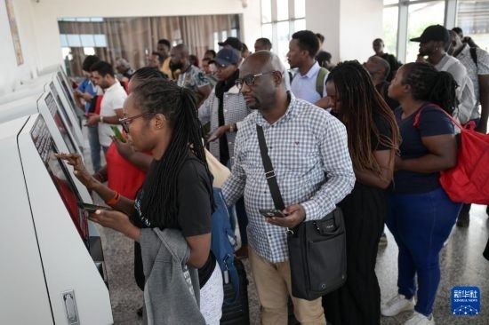 5月31日，在蒙內(nèi)鐵路內(nèi)羅畢站，乘客在自助取票機前排隊取票。新華社記者 楊光 攝